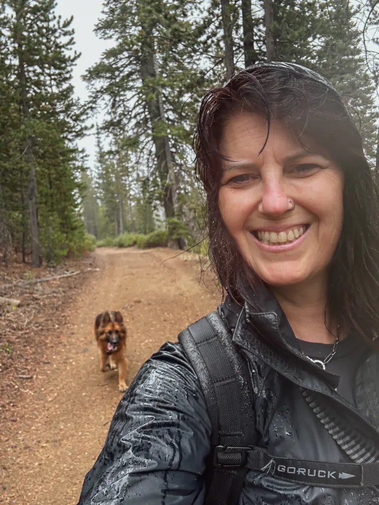 Woman and dog hiking in the rain.