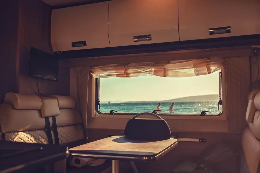 Popup camper interior booth and table with a window.