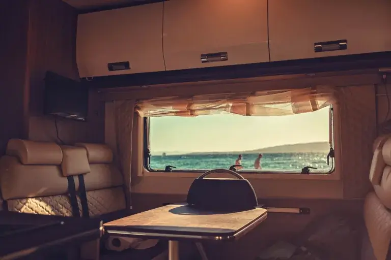 Popup camper interior booth and table with a window.