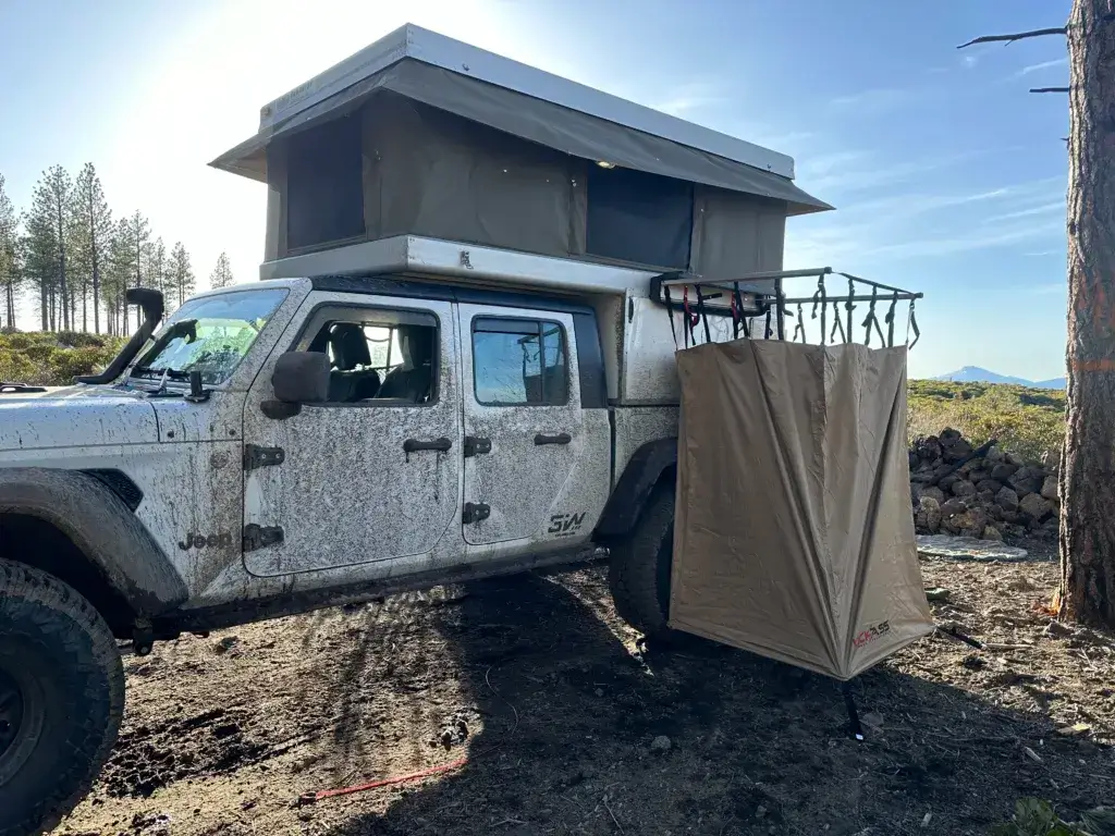 Jeep Gladiator with a camping shower opened up on the side.