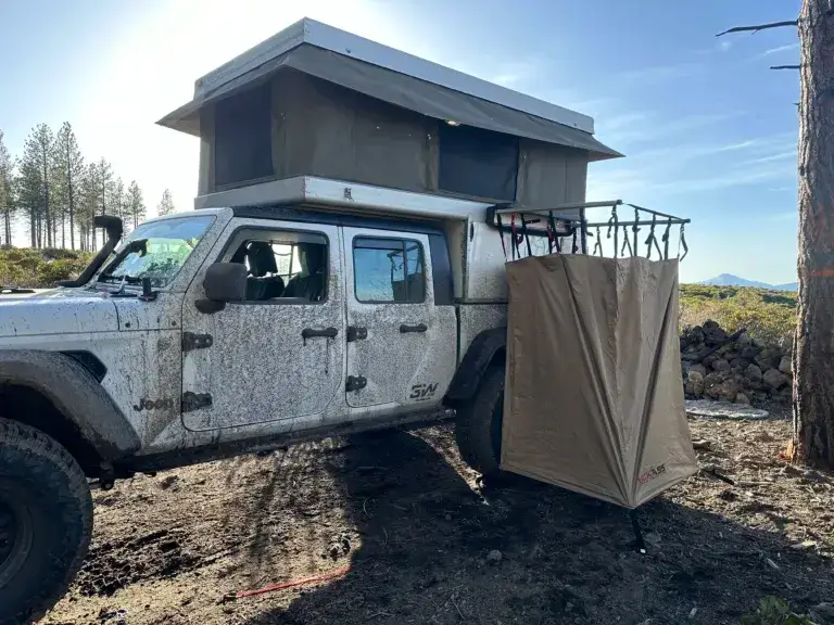 Jeep Gladiator with a camping shower opened up on the side.