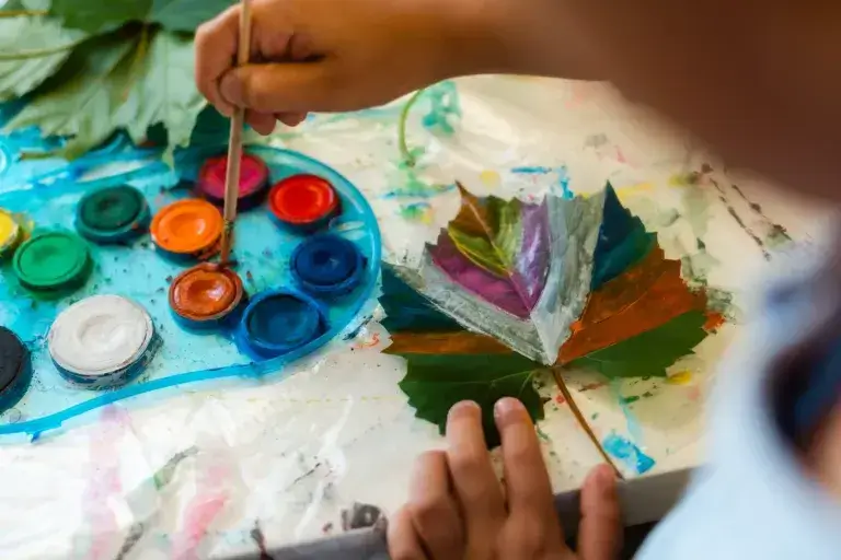 Autumn camping craft for kids painted maple leaf.