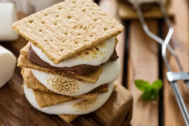 A stack of smores on a wood surface.