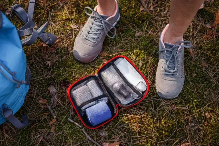 a person's feet standing next to a first aid kit