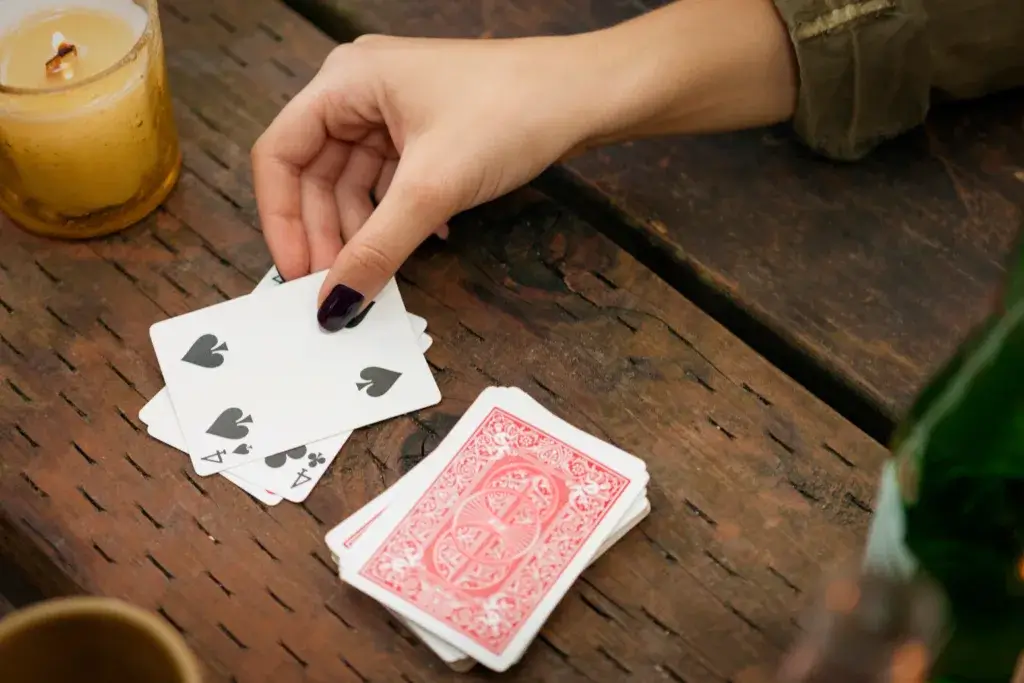Hand on a camping table playing cards.