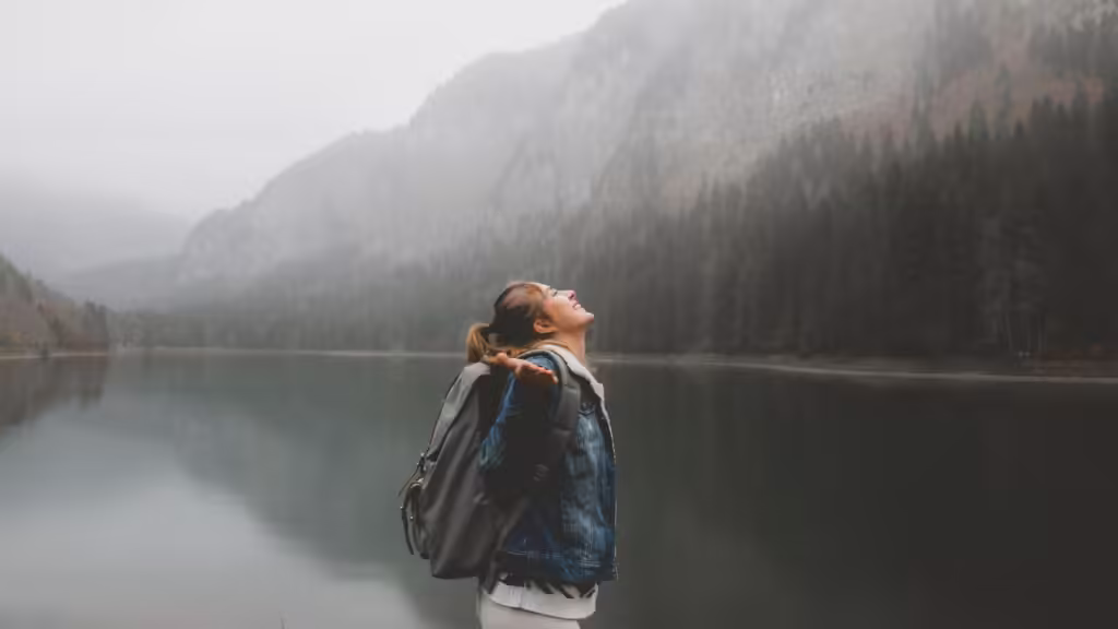 Attractive female hiker enjoys the view of lake Montriond in French Alps on a rainy day.