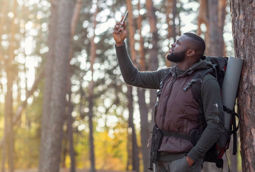 Man on a solo hike looking at a Gps device.