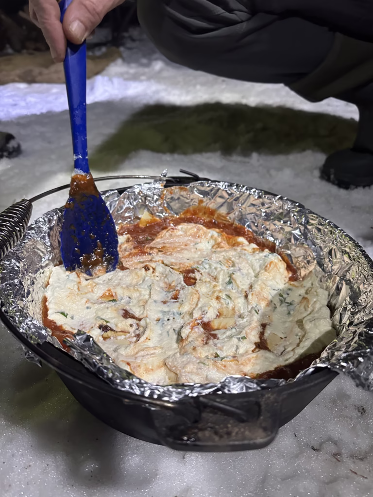Dutch oven lasagna as snowy camp.