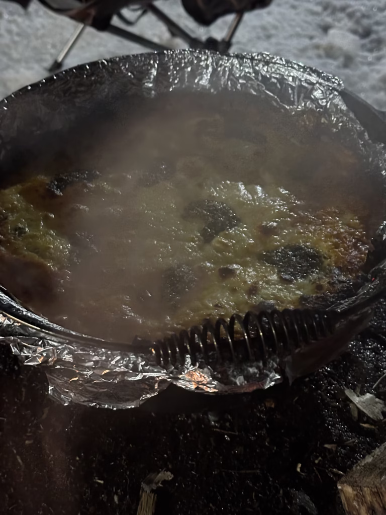Dutch Oven lasagna completed with melty cheese on top.