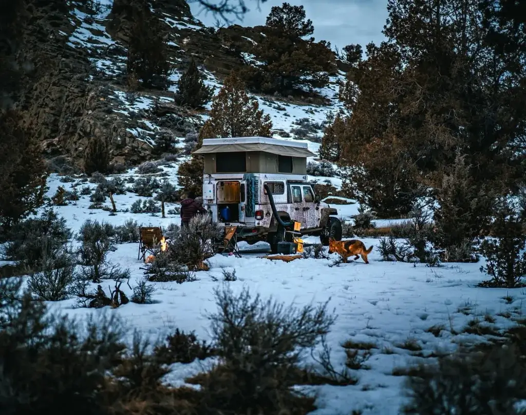 Jeep gladiator with rooftop tent camping in the snow.