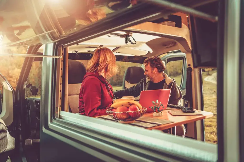 Couple smiling in a camper van.