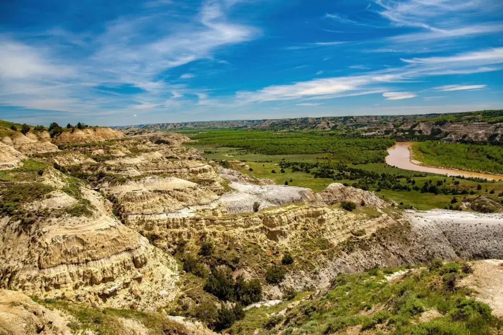 The Badlands National Park in South Dakota on a sunny day with blue skies.