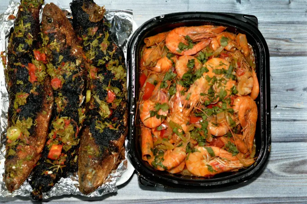 Chili lime shrimp in a tin foil pack sitting on a picnic table.