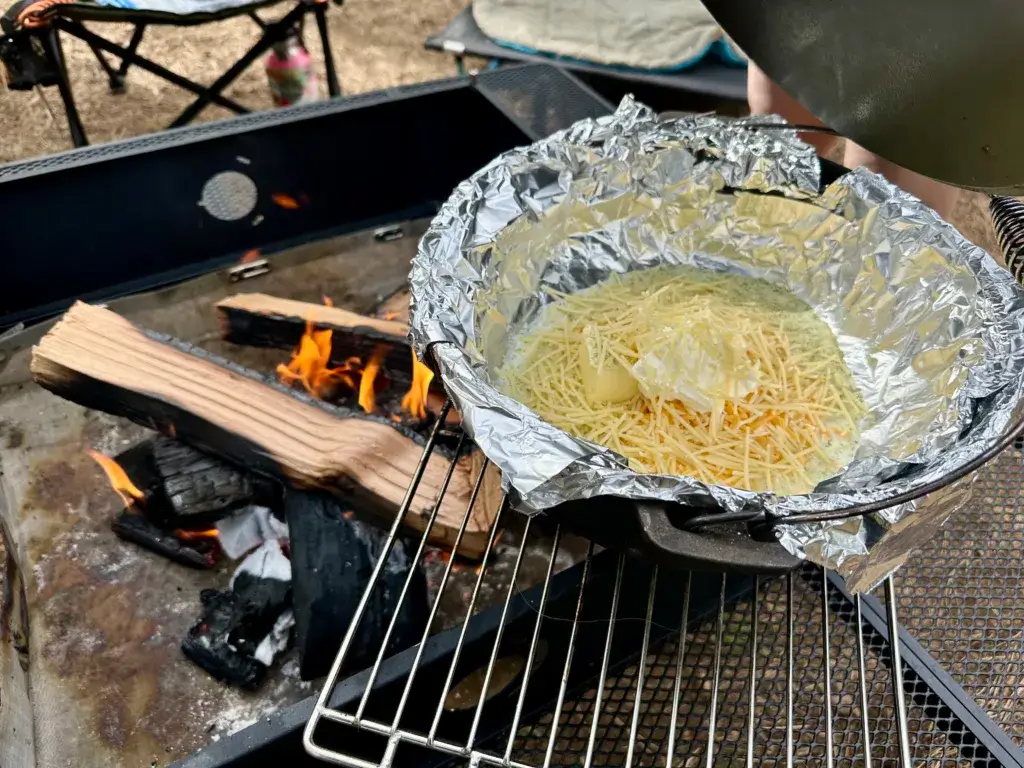 Ingredients for ranch Mac N Cheese in a dutch oven lined with tin foil.
