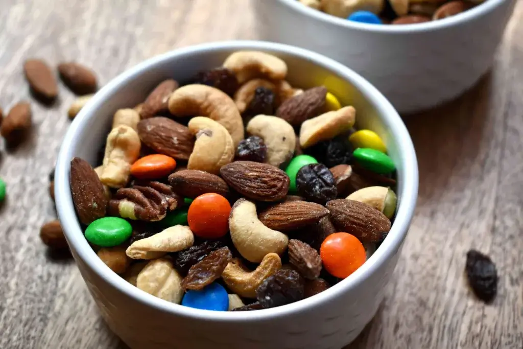 Bowl of trail mix with nuts and chocolate.