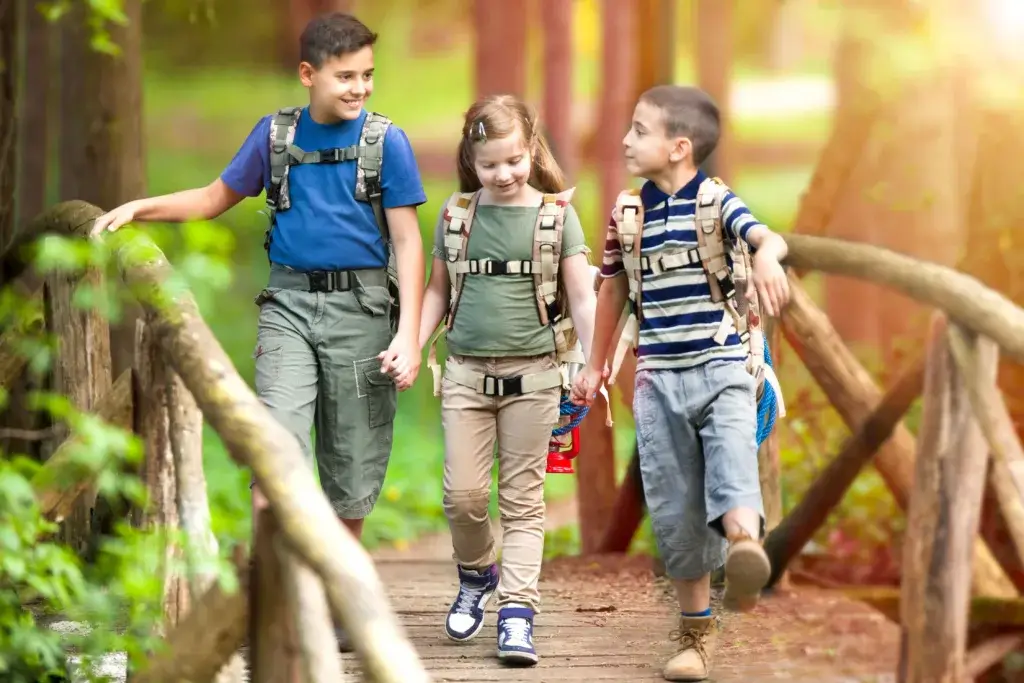 Children on a camping trip wearing backpacks.