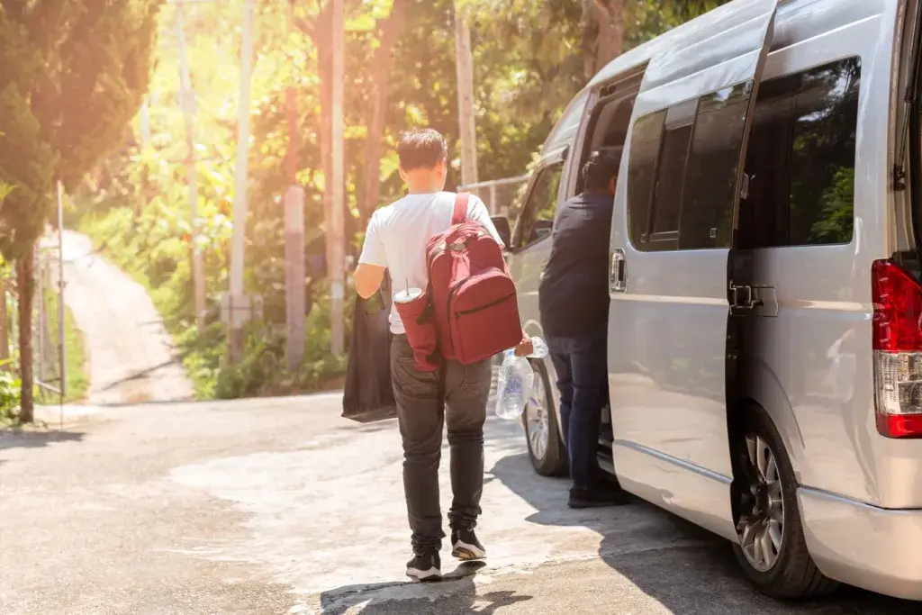 Vanlife Man with a backpack standing next to a van.