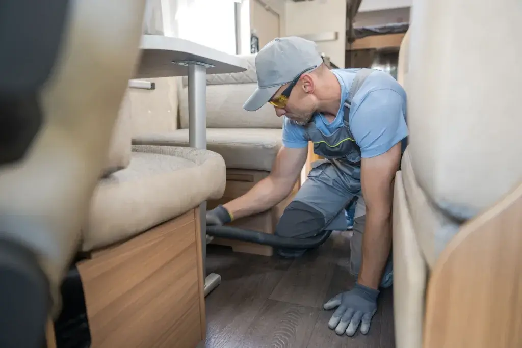 Man sweeping RV wood style flooring.