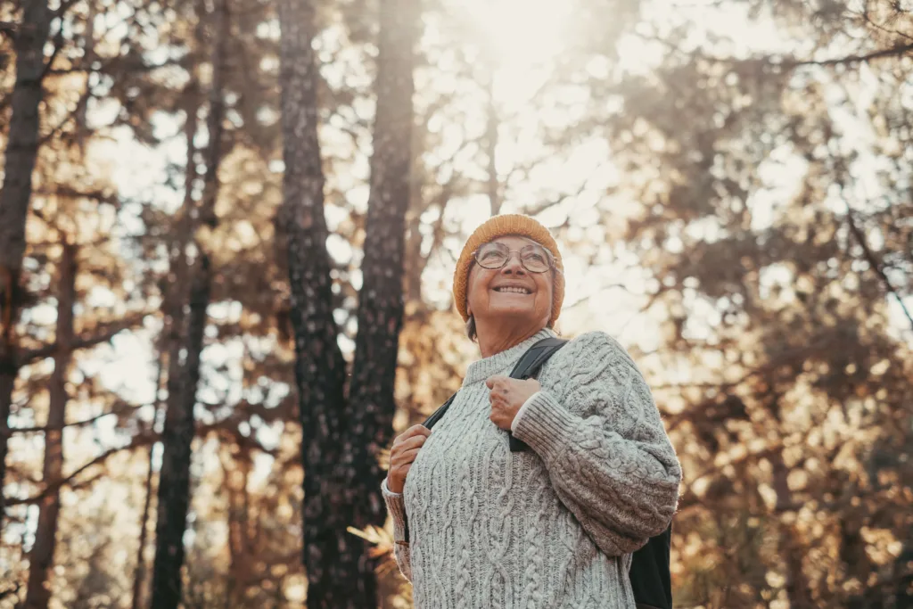 A woman taking a leisurely hike through the trees.