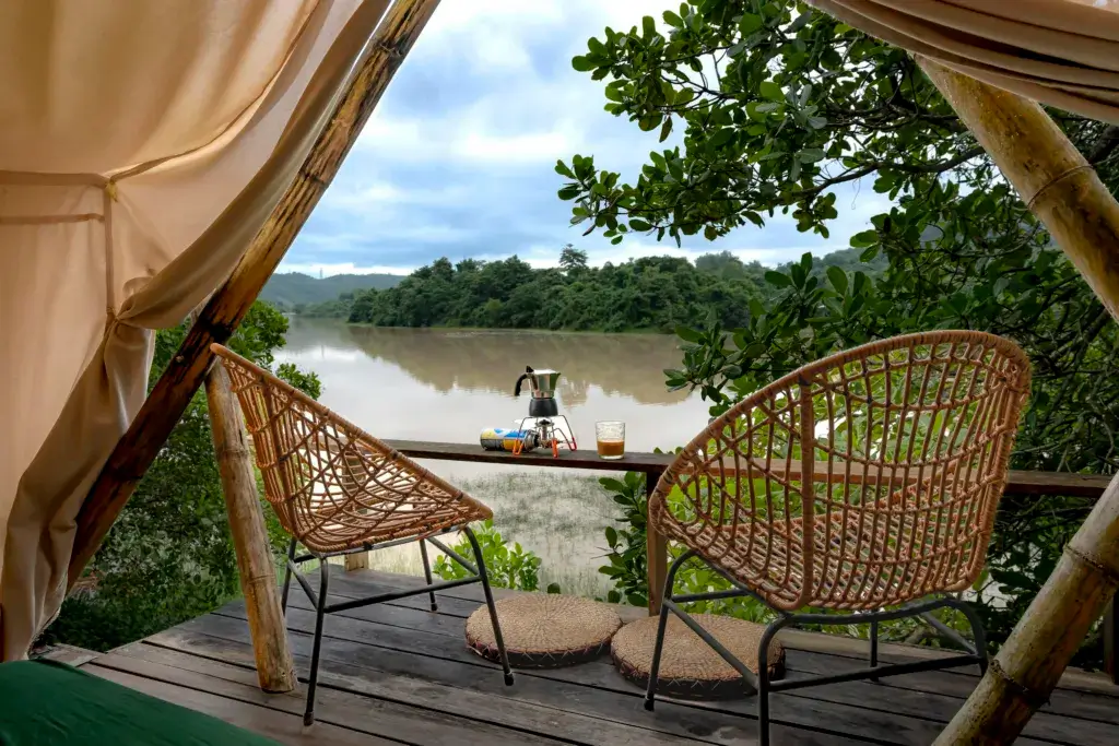 Relaxing riverside view with wicker chairs and a teapot on the terrace