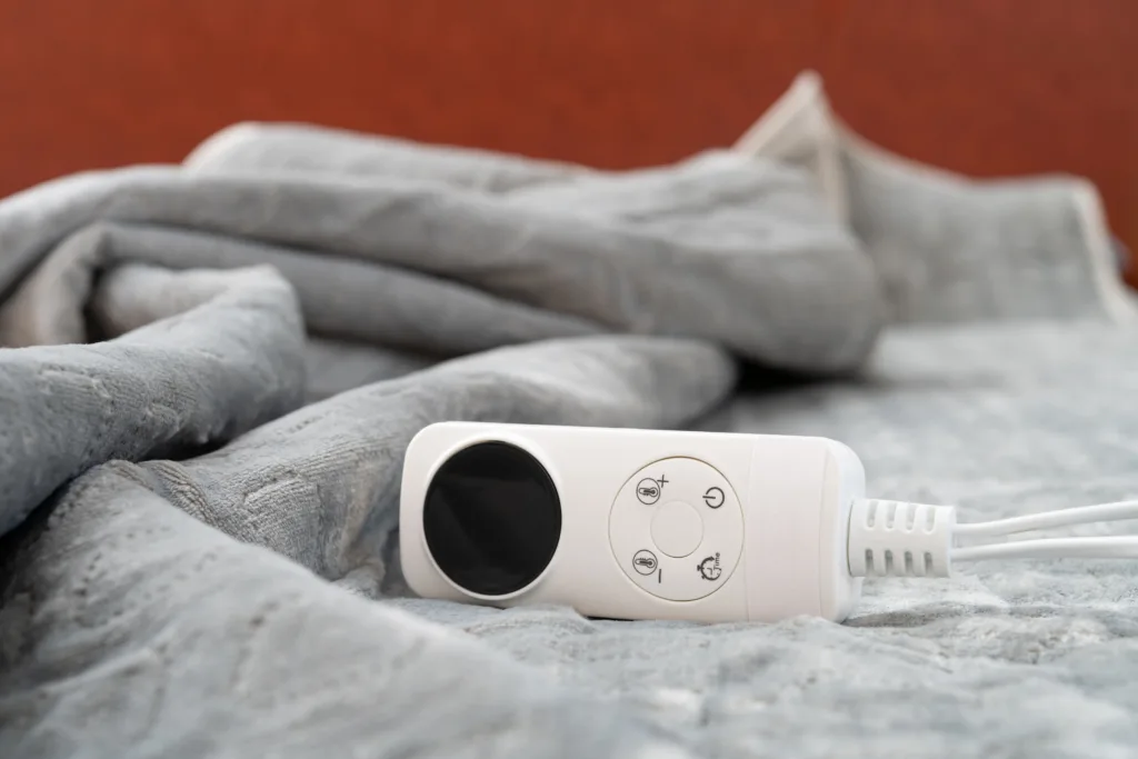 Light grey electric blanket with white controller.