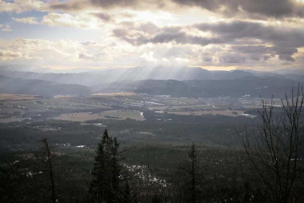 A breathtaking view of mountains under dramatic skies with sun rays breaking through clouds.