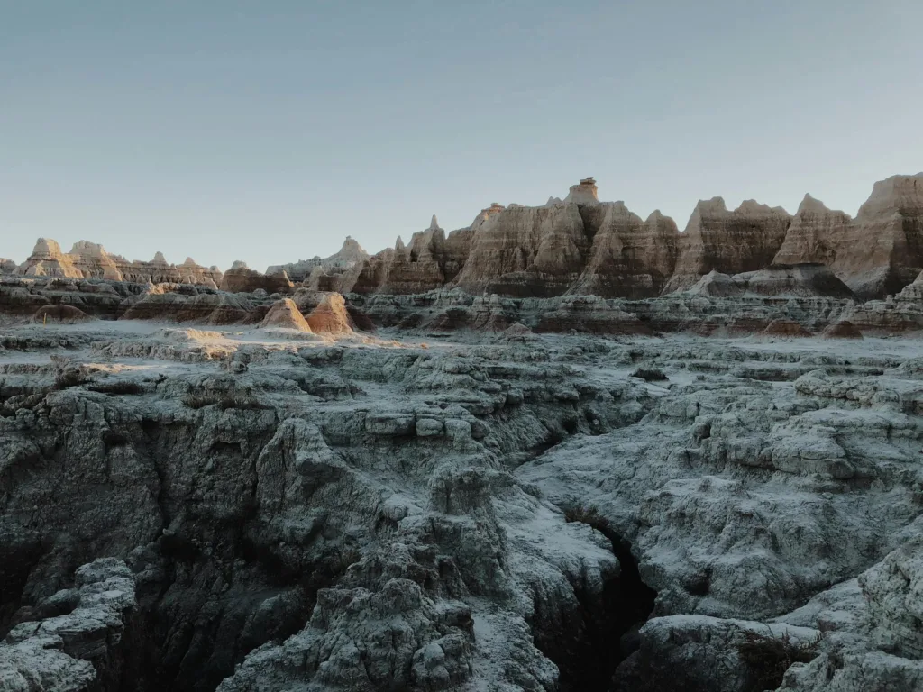 Dramatic rock formations in Badlands National Park under a clear blue sky, showcasing natural geological wonders.