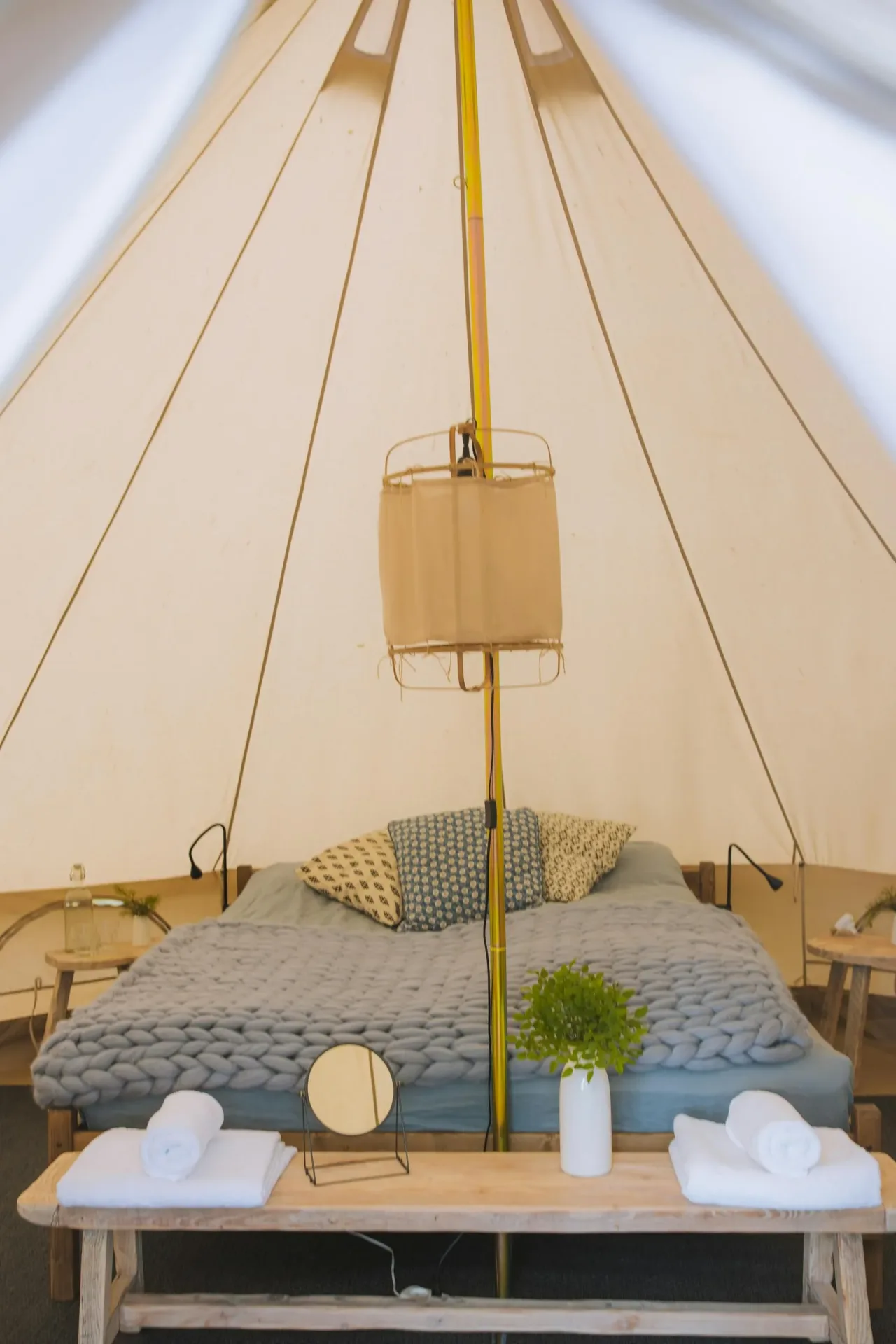 Experience ultimate comfort with this stylish glamping tent featuring a plush bed and elegant decor.