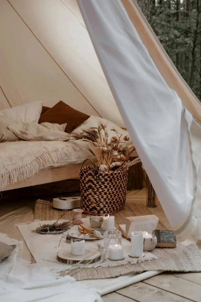 Luxurious glamping tent set up with chic decor and candles, perfect for a romantic getaway.
