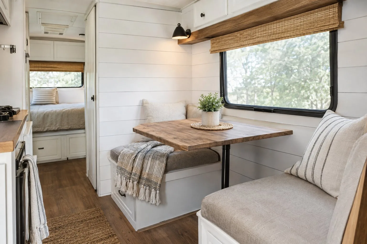 A camper dinette beside a white paneled wall.