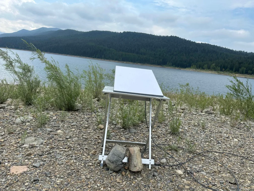 Starlink sitting on a table with a lake in the background.