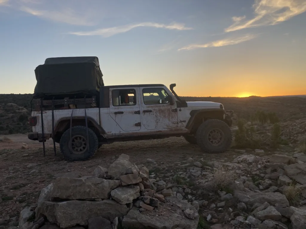 Jeep Gladiator with rooftop tent in Moab, Utah at sunset.