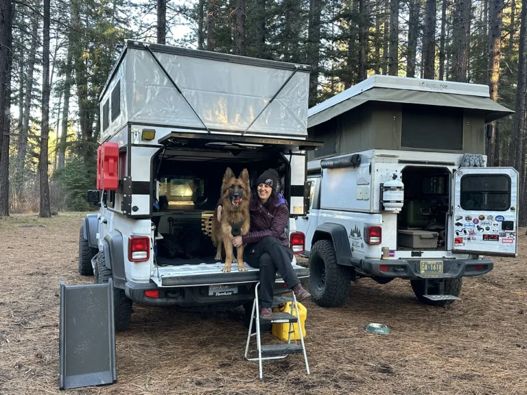 Woman and German Shepherd dog sitting on the tailgate of a Jeep with Project M camper.