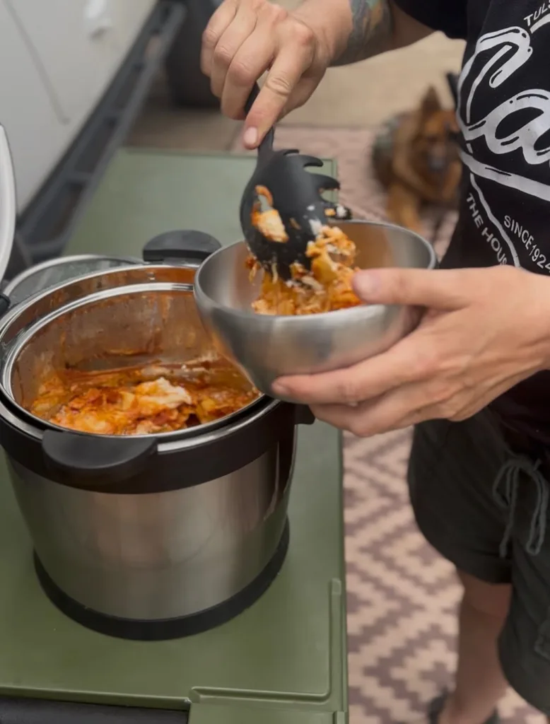 Scooping enchiladas out of Rockpot into a bowl.