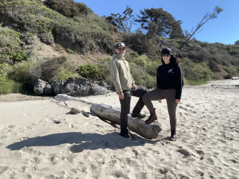 Man and woman at the beach wearing KUHL pants.